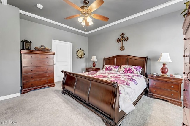 bedroom featuring a tray ceiling, ceiling fan, baseboards, and light carpet