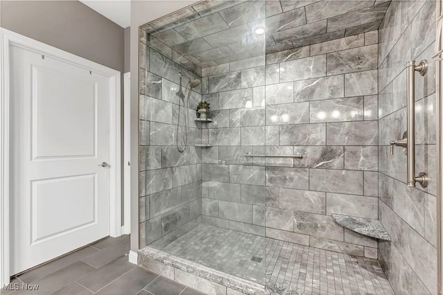 bathroom featuring a tile shower and tile patterned flooring