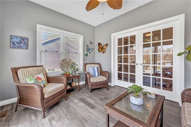 sitting room with plenty of natural light, french doors, baseboards, and ceiling fan