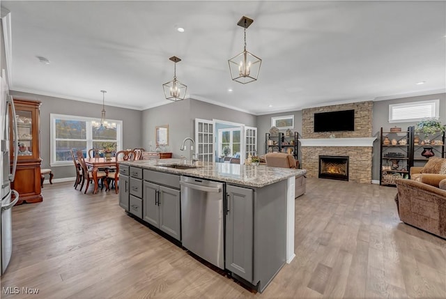 kitchen featuring an inviting chandelier, dishwasher, gray cabinets, a sink, and light wood-style floors