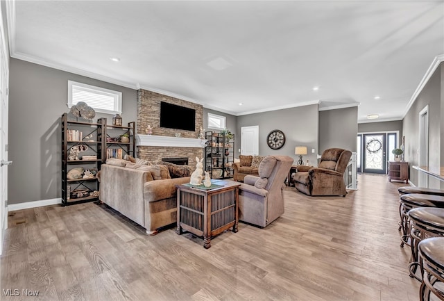 living room with ornamental molding, light wood finished floors, and a fireplace