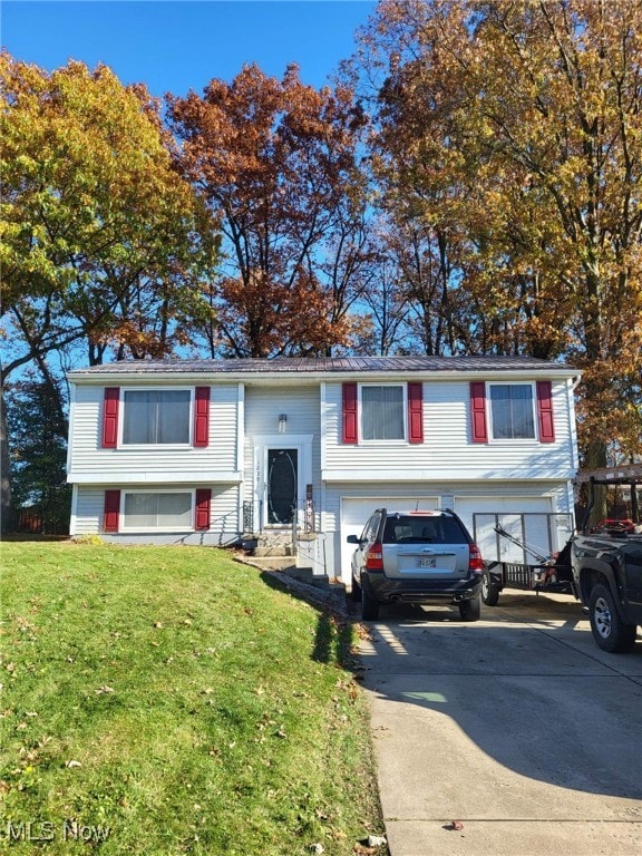 1239 Woodledge Dr, Mineral Ridge, OH 44440 - raised ranch with concrete driveway, a front lawn, and a garage