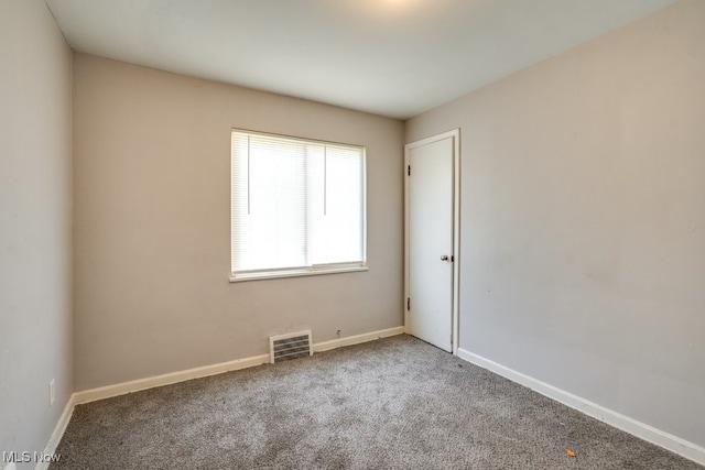 unfurnished room with baseboards, visible vents, and carpet flooring