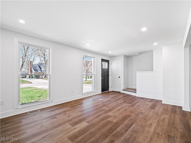interior space with wood finished floors, visible vents, and a healthy amount of sunlight