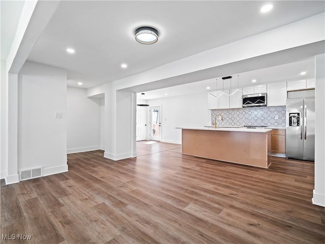 unfurnished living room with dark wood-type flooring, visible vents, baseboards, and recessed lighting