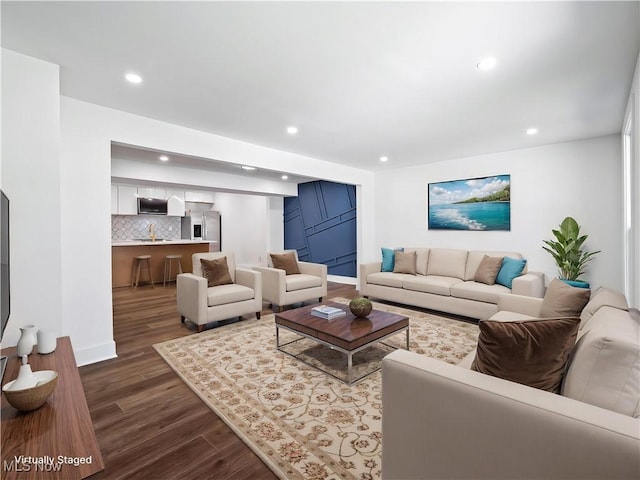 living area featuring dark wood-type flooring and recessed lighting
