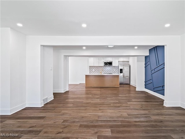 unfurnished living room with baseboards, recessed lighting, and dark wood-style floors