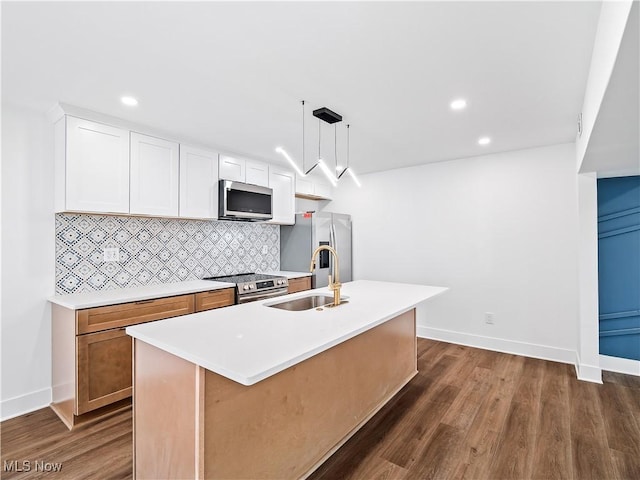 kitchen featuring backsplash, baseboards, stainless steel appliances, and a sink