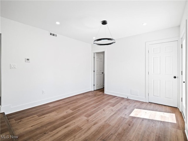 interior space featuring recessed lighting, wood finished floors, visible vents, and baseboards
