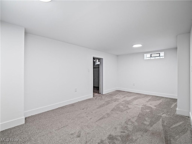 below grade area featuring carpet flooring and baseboards