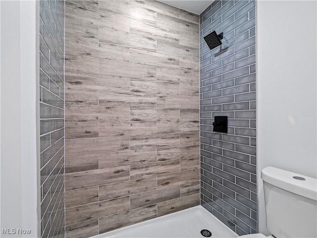 bathroom featuring a shower stall and toilet