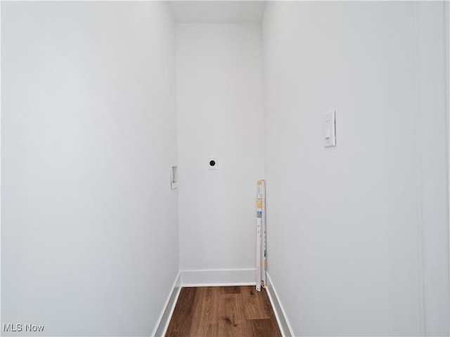 clothes washing area featuring dark wood finished floors, baseboards, laundry area, and hookup for an electric dryer