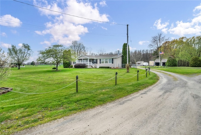 view of front of property with dirt driveway and a front yard
