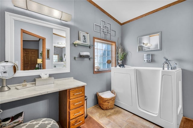 full bathroom featuring a washtub, vaulted ceiling, vanity, and crown molding