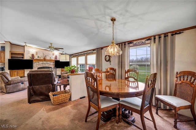 carpeted dining space featuring a wealth of natural light, ornamental molding, and ceiling fan with notable chandelier