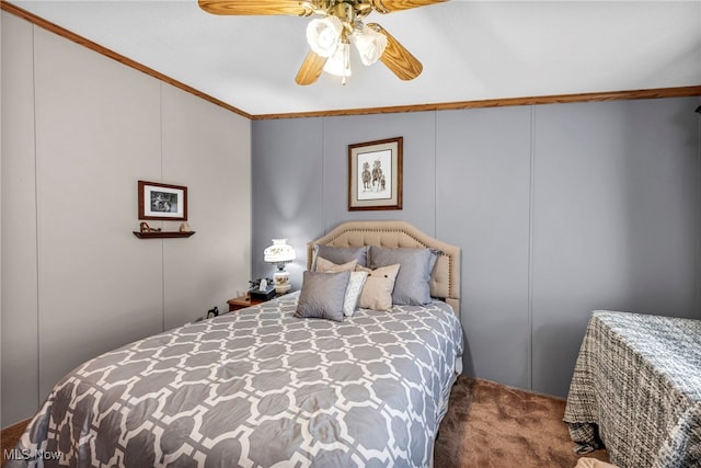 carpeted bedroom featuring a decorative wall, ceiling fan, and crown molding