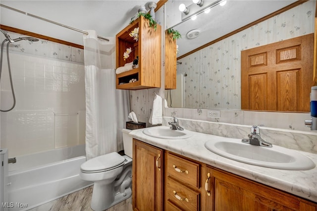 bathroom with wallpapered walls, a sink, shower / bathtub combination with curtain, and crown molding