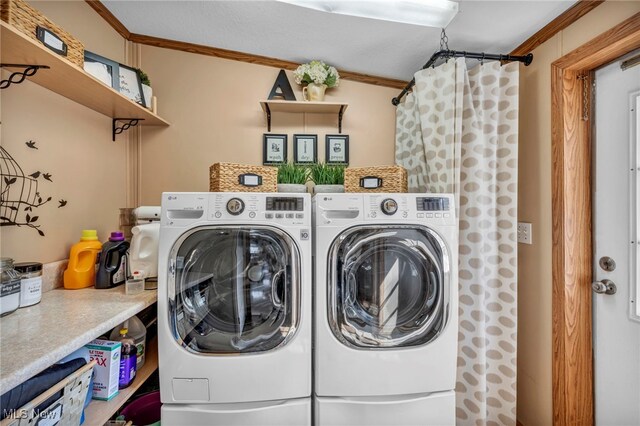 clothes washing area with separate washer and dryer, ornamental molding, and laundry area