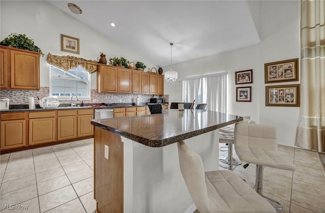kitchen with light tile patterned floors, a wealth of natural light, tasteful backsplash, and a breakfast bar area