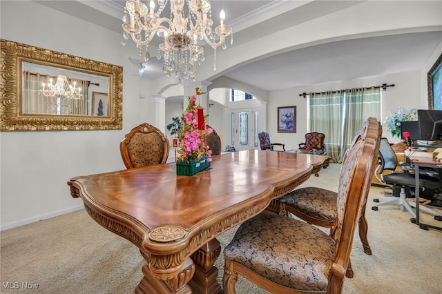 dining area with crown molding, carpet, arched walkways, and an inviting chandelier