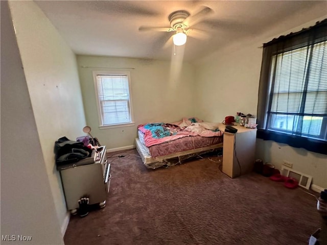 bedroom with carpet, visible vents, baseboards, and multiple windows