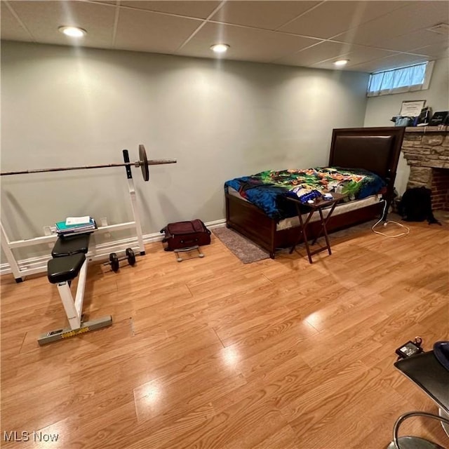 bedroom with wood finished floors, a paneled ceiling, and baseboards