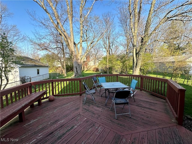 wooden terrace with a yard and outdoor dining area
