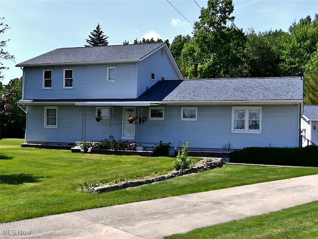 traditional-style home with a front lawn and brick siding