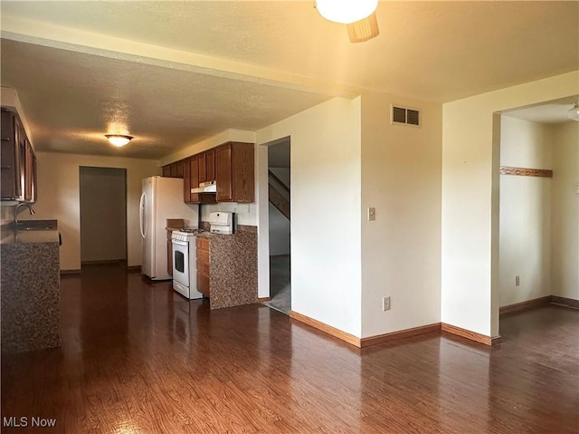 3799 Larchmont Ave NE, Bazetta, OH 44483 - kitchen with white appliances, dark wood-style flooring, under cabinet range hood, and baseboards