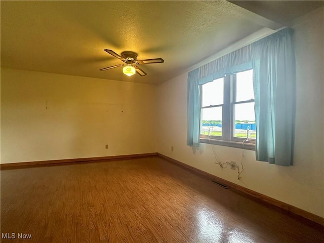 3799 Larchmont Ave NE, Bazetta, OH 44483 - spare room featuring wood finished floors, baseboards, a ceiling fan, and a textured ceiling