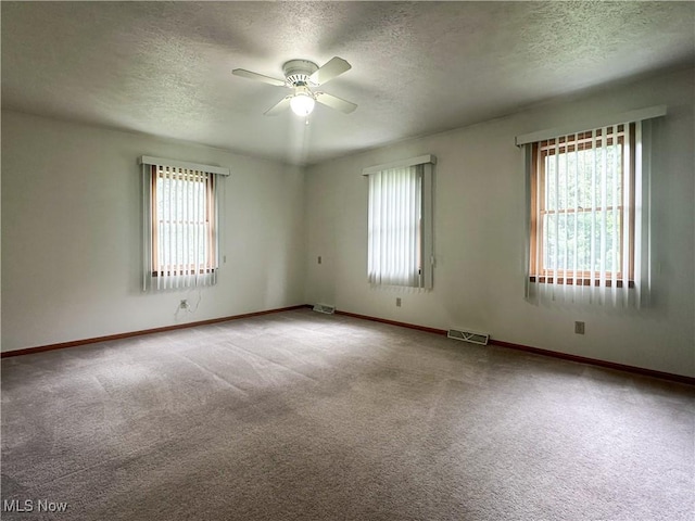3799 Larchmont Ave NE, Bazetta, OH 44483 - unfurnished room with a textured ceiling, plenty of natural light, ceiling fan, and carpet floors