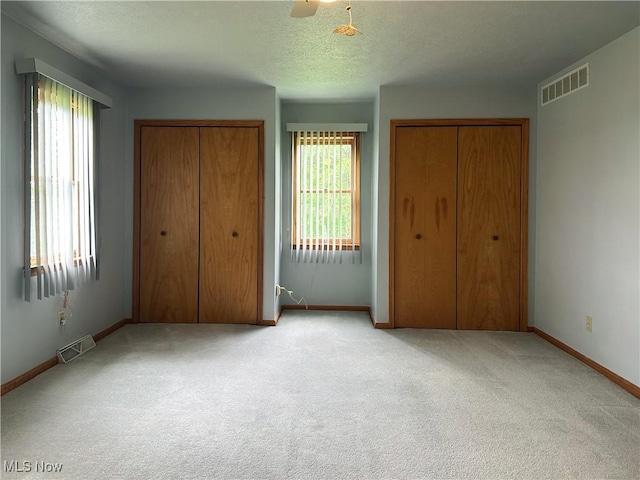 3799 Larchmont Ave NE, Bazetta, OH 44483 - unfurnished bedroom with two closets, baseboards, carpet floors, a textured ceiling, and a ceiling fan