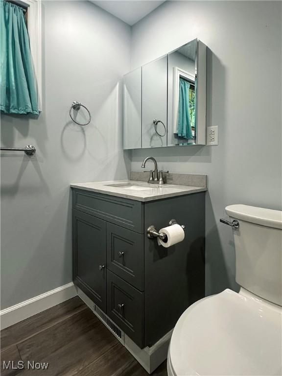 3799 Larchmont Ave NE, Bazetta, OH 44483 - half bath featuring vanity, toilet, wood finished floors, and baseboards