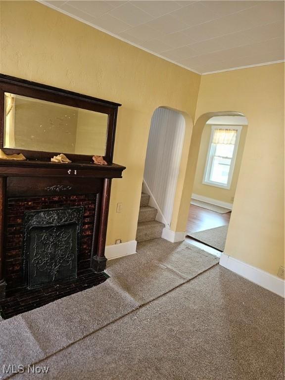606 S 7th St, Cambridge, OH 43725 - unfurnished living room with ornamental molding, arched walkways, baseboards, a high end fireplace, and stairs