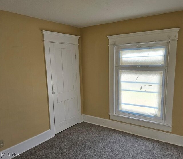 606 S 7th St, Cambridge, OH 43725 - unfurnished room with dark colored carpet, plenty of natural light, and baseboards