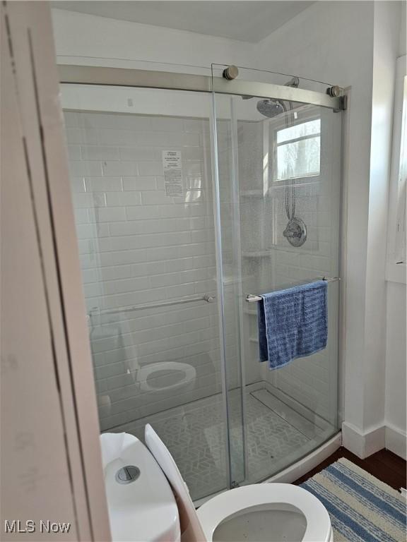 606 S 7th St, Cambridge, OH 43725 - bathroom with toilet, a stall shower, and wood finished floors