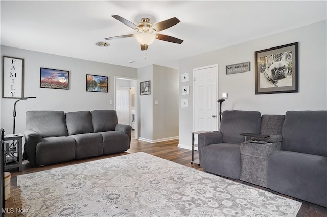 living room featuring baseboards, a ceiling fan, wood finished floors, and visible vents