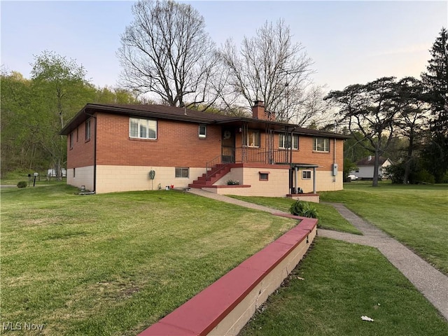 243 Hagan St, Adena, OH 43901 - rear view of property with a lawn, brick siding, and a chimney