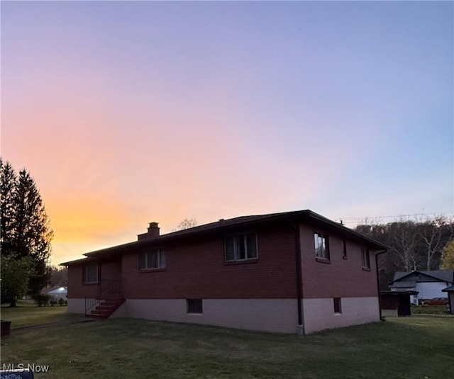 243 Hagan St, Adena, OH 43901 - view of side of home with a lawn, brick siding, and a chimney
