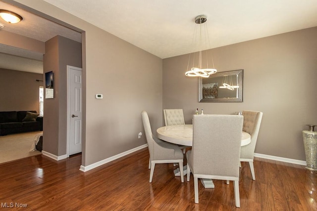 dining area with baseboards, a chandelier, and wood finished floors