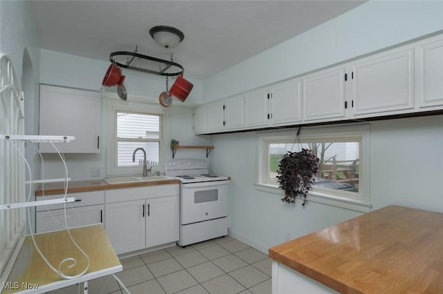 kitchen with white electric range, a sink, light tile patterned floors, light countertops, and white cabinets