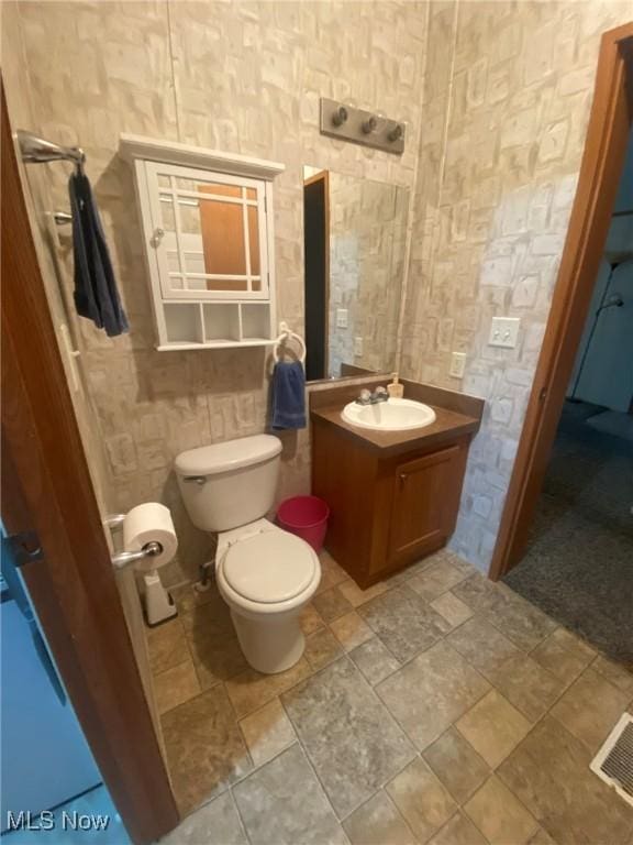 bathroom featuring visible vents, vanity, and toilet