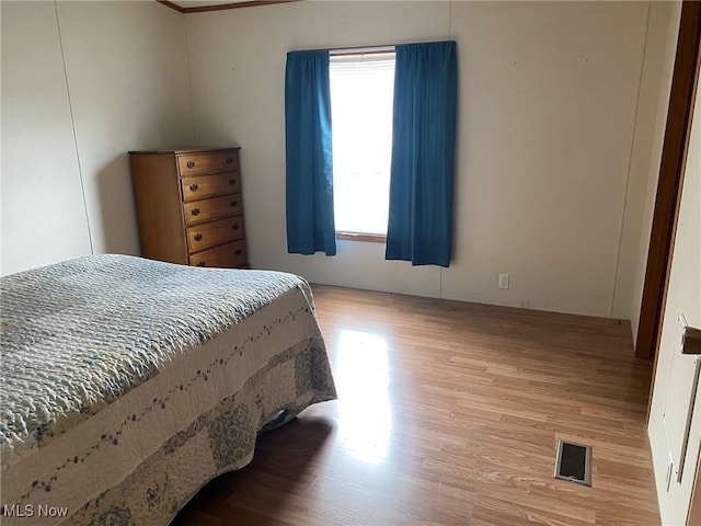 bedroom with visible vents and wood finished floors