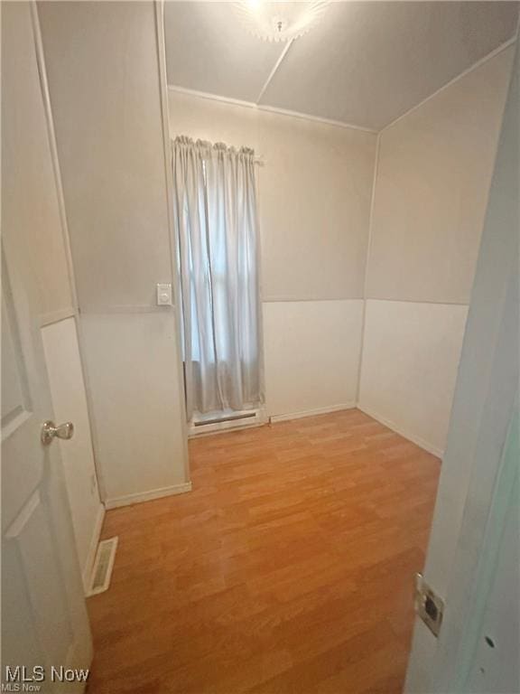 unfurnished room featuring visible vents, baseboards, and wood finished floors