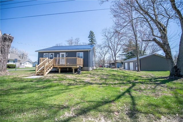back of house with metal roof, stairs, a wooden deck, a lawn, and a garage