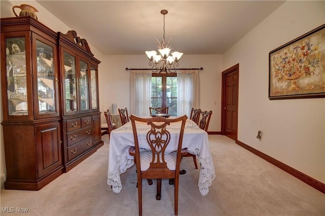 dining room with a chandelier, baseboards, and light carpet