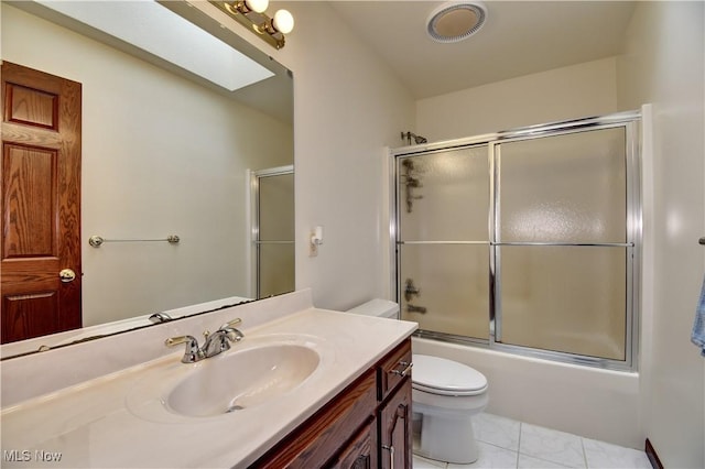 bathroom featuring toilet, vanity, bath / shower combo with glass door, and visible vents