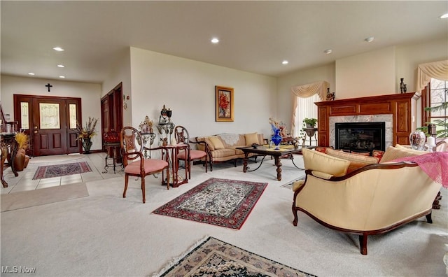living room featuring recessed lighting, a fireplace, light colored carpet, and light tile patterned flooring