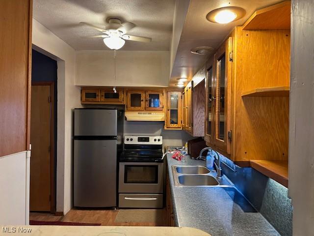 214 Jarvis St, Bowerston, OH 44695 - kitchen with a sink, brown cabinetry, ceiling fan, appliances with stainless steel finishes, and under cabinet range hood