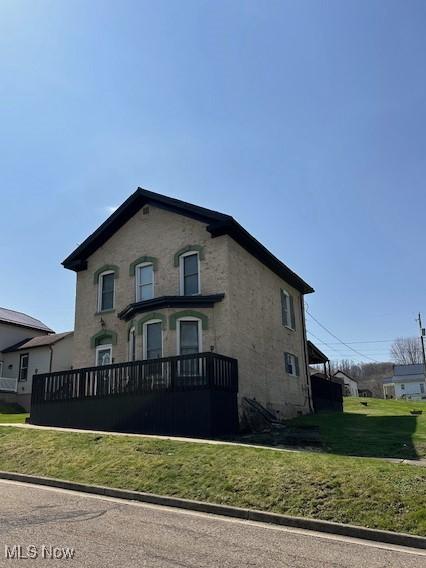214 Jarvis St, Bowerston, OH 44695 - view of front of home featuring a front lawn and stucco siding